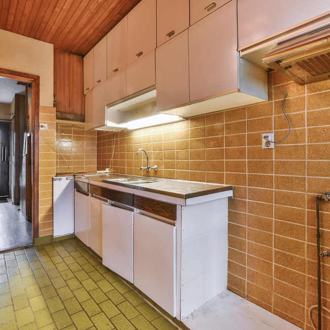 Outdated kitchen tiles before renovation and tile replacement