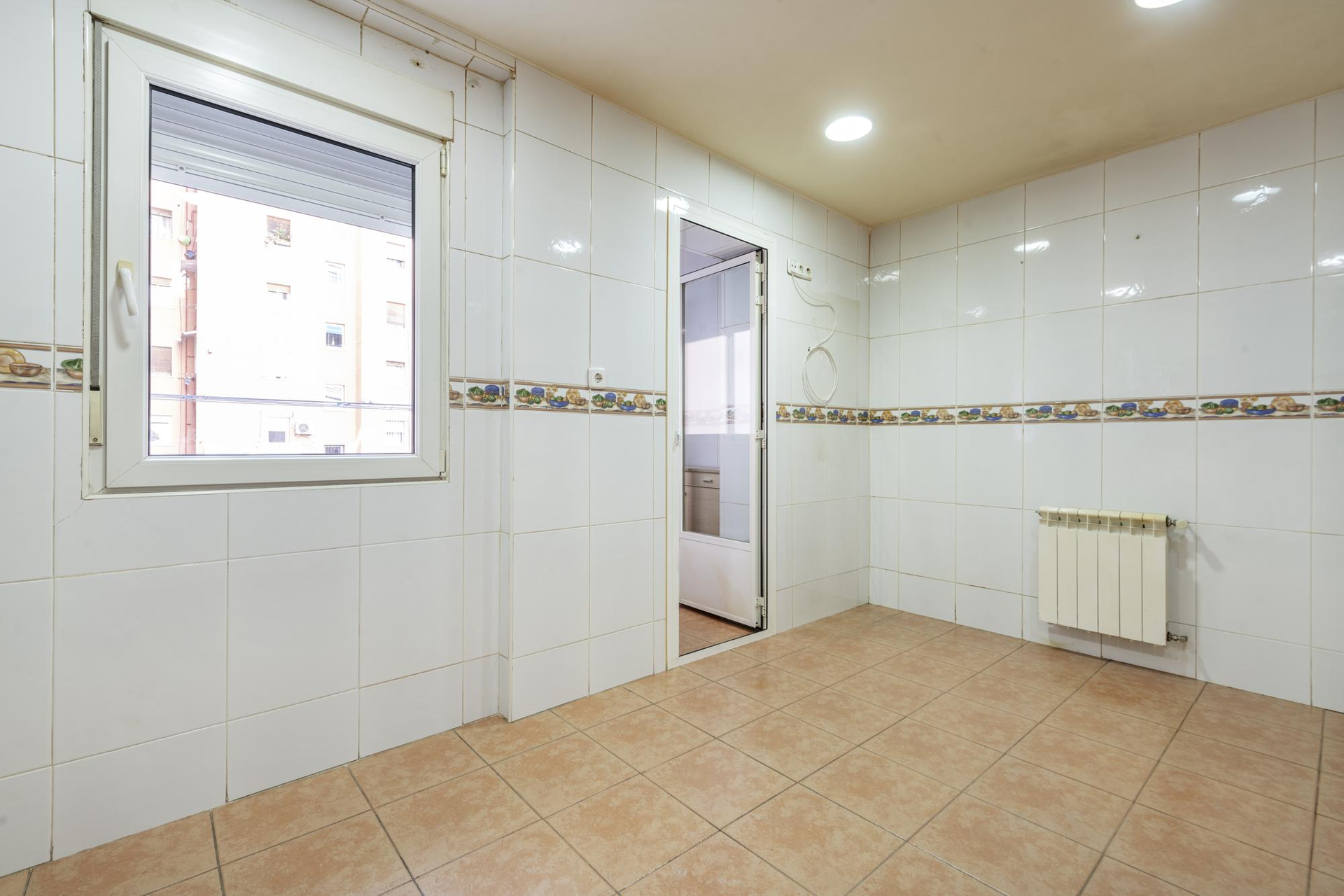 White ceramic wall and floor tiles in a renovated kitchen