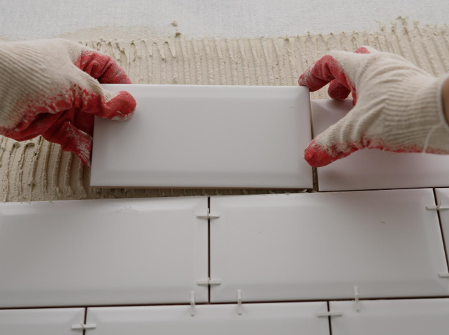 Los Angeles Tiles Worker installing white ceramic tile